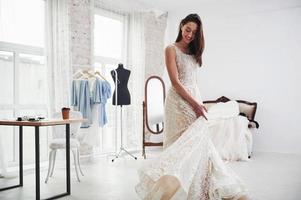 la parte de la boda está esperando. el proceso de ajuste del vestido en el estudio de ropa artesanal foto