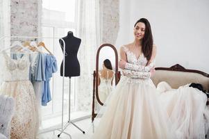 With arms crossed. The process of fitting the dress in the studio of hand crafted clothes photo