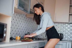 Concentrated at process. Girl in the modern kitchen at home at her weekend in the morning time photo