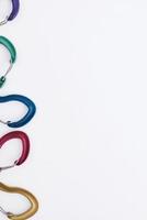 For the climbing. Many of the multi colored carabiners on lying on the white table photo