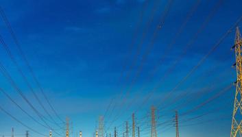poste eléctrico de alto voltaje y líneas de transmisión por la noche. torres de alta tensión en la noche. poder y energía. conservación de energía. torre de red de alto voltaje con cable de alambre en la estación de distribución. foto