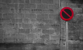 No parking sign. Regulatory sign. Circle red and black no parking sign on post. Traffic sign on gray and white brick wall texture background. Road signs for prohibit car parking. Restrictive signs.