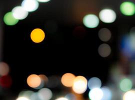 fondo abstracto bokeh azul, naranja, verde, rojo y blanco borroso. desenfoque bokeh sobre fondo oscuro. luz de la ciudad en la noche. navidad o fondo de navidad. efecto de luz de calle con hermoso patrón foto