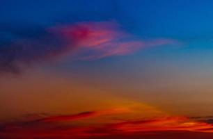 Dramático cielo rojo y azul y fondo abstracto de nubes. nubes rojo-azules en el cielo del atardecer. fondo de clima cálido. imagen artística del cielo al atardecer. fondo abstracto al atardecer. triste y dramático cielo de puesta de sol. foto
