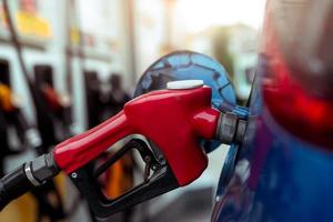 Car fueling at gas station. Refuel fill up with petrol gasoline. Petrol pump filling fuel nozzle in fuel tank of car at gas station. Petrol industry and service. Petrol price and oil crisis concept. photo