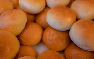 Heap of soft bread. Fresh baked bread made from white flour. Closeup soft bread for breakfast or dinner. Small circle roll bread. Carbohydrates food. Bakery in hotel at breakfast buffet counter. photo