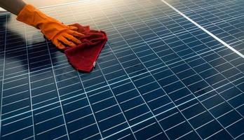 hombre limpiando panel solar en el techo. mantenimiento de paneles solares o módulos fotovoltaicos. recurso sostenible y energía renovable para el concepto verde. energía solar para energía verde. tecnología para el futuro. foto