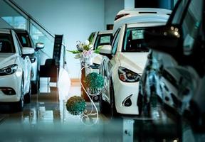 New luxury shiny compact car parked in modern showroom. Car dealership office. Car retail shop. Electric car technology and business concept. Automobile rental concept. Automotive industry. Promotions photo