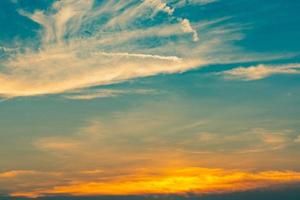 Beautiful blue and golden sky and clouds abstract background. Yellow-orange clouds on sunset sky. Warm weather background. Art picture of sky at sunset. Sunset and fluffy clouds for inspiration. photo