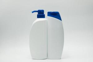 juego de botella de champú y acondicionador con tapa azul y bomba dispensadora sobre fondo blanco con etiqueta en blanco y espacio de copia. Uso para publicidad de champú y acondicionador. paquete de productos cosméticos. belleza foto