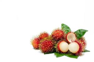 Closeup of fresh red ripe rambutan Nephelium lappaceum with leaves isolated on white background with clipping path. Thai dessert sweet fruits. Tropical fruit.