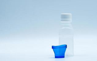 loción ocular estéril en botella de plástico blanco con baño de ojos azul y espacio de copia y etiqueta en blanco. lavado de ojos después de la contaminación del contacto con el medio ambiente o después de nadar en una piscina contaminada con cloro.
