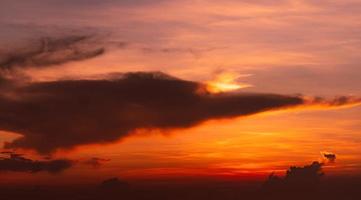 Dramático cielo rojo y naranja al atardecer y fondo abstracto de nubes. nubes de color rojo anaranjado en el cielo del atardecer. cielo cielo fondo abstracto al atardecer. concepto de atardecer y amanecer. cielo romántico. belleza en la naturaleza. foto