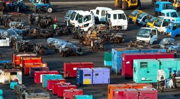 Heavy machinery second hand market. Old electric generator, tractor, diesel engine on dirty concrete floor. Warehouse of heavy machinery for sale. Used heavy equipment and diesel engine for sale. photo