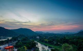 hermoso paisaje natural de la cordillera con el cielo del amanecer y las nubes. ciudad en el valle de la montaña en tailandia. paisaje de capa montañosa con amanecer matutino. bosque tropical. fondo de la naturaleza. foto