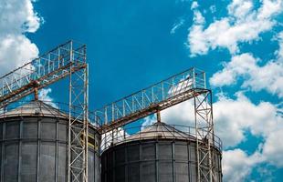 Agricultural silo at feed mill factory. Flat silo for store and drying grain, wheat, corn at farm. Storage of agricultural product. Big tank for store grain. Grain stock tower. Agriculture industry. photo