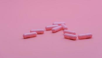 Pink capsules pill on pink background. Vitamins and supplements. Online pharmacy. Pharmacy store banner. Pharmaceutical industry. Woman's health insurance concept. Pills for love and happy life. photo