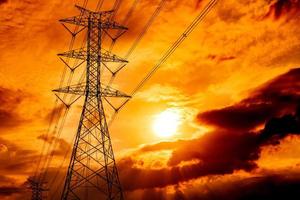 High voltage electric pole and transmission lines. Electricity pylons at sunset. Power and energy. Energy conservation. High voltage grid tower with wire cable at distribution station.