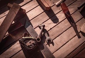 Carpenter tools on workbench. Carpentry work with old tools. DIY equipment for carpenter. Woodwork  workshop. Woodwork on vintage background. Old chisel, tape measure, and wrench on wooden bench. photo