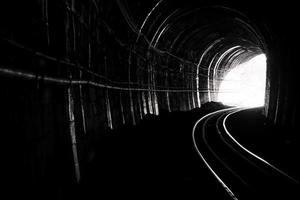 túnel del tren. antiguo ferrocarril en cueva. esperanza de vida al final del camino. ferrocarril de locomotora en tailandia. arquitectura antigua túnel ferroviario construido en 1914. viaje y esperanza en el destino. foto