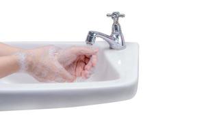 mujer lavándose las manos con espuma de jabón y agua del grifo en el baño. limpie a mano bajo el grifo del fregadero para la higiene personal para prevenir la gripe y el coronavirus. buen procedimiento de lavado de manos para matar bacterias, virus. foto