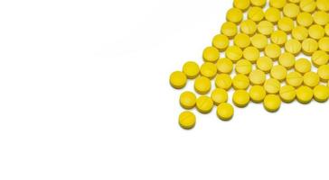 Yellow small round tablets pills on white background. Healthcare concept. Painkillers medicine. Nonsteroidal anti-inflammatory drugs NSAIDs. Pharmaceutical industry. Painkillers or analgesic drug. photo