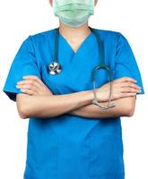 el médico cirujano usa uniforme de camisa azul y mascarilla verde. médico de pie con los brazos cruzados y estetoscopio de mano. profesional de la salud. médico cirujano de pie con confianza. confianza.