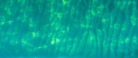 Fondo de textura abstracta verde de agua de mar verde esmeralda. vista superior del agua de mar verde con un patrón único. fondo verde superficie de onda de agua de mar en la costa. agua turquesa en mar poco profundo. foto
