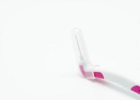 cepillo interdental con mango de plástico blanco y rosa aislado sobre fondo blanco. cepillos de dientes interdentales para la higiene bucal. cepillos de frenos. cuidado dental o buen concepto de higiene dental. herramientas médicas. foto