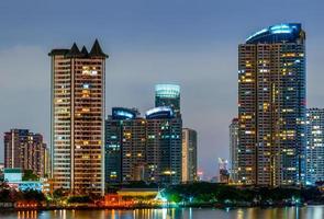 Cityscape of modern building near the river in the night. Modern architecture office building. Skyscraper with evening sky. Night photography of riverfront building. Condominium open light in night. photo
