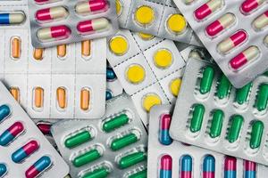 Top view of colorful tablets and capsules pills in blister packs. Global health care and drug use with reasonable concept. Full frame of pile of pills photo