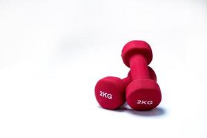 Set of red dumbbells isolated on white background. A pair of red neoprene dumbbells. Home gym equipment for exercise at home. Weight training equipment. Small dumbbells for muscle strength building photo