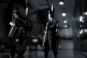 silla de ruedas vacía borrosa en el pasillo del hospital por la noche para pacientes de servicio y personas discapacitadas. equipo médico en el hospital para personas discapacitadas de asistencia. silla con ruedas para cuidado de pacientes. foto