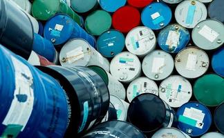 Old chemical barrels. Blue, red, and green chemical drum. Steel tank. Hazard chemical barrel with flammable liquid warning label. Industrial waste. Isopropyl alcohol and aluminized orgonosol barrels. photo