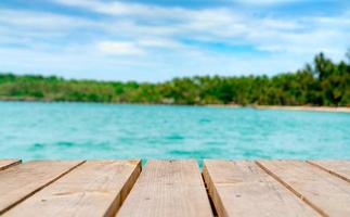 Product display for summer promotion. Wooden bridge on blurred water, coconut tree and sand beach. Empty space for product display montage. Banner for advertise on online media, Business presentation. photo