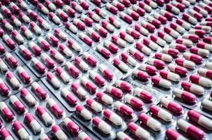 píldoras de cápsula antibiótica rosa-blanca en blíster. resistencia a fármacos antibióticos. industria de envases farmacéuticos. asistencia sanitaria mundial. fondo de farmacia. producto farmacéutico. línea de producción.