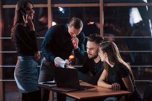 tienes que comprobar esto. equipo de jóvenes empresarios trabaja en su proyecto por la noche en la oficina foto