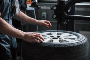 No face photo. Young man works with wheel's disks at the workshop at daytime photo