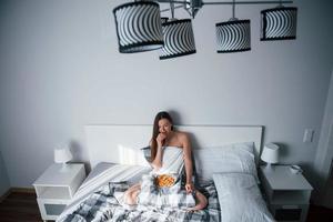 Alone in the room. Pretty young woman lying on the bed at morning time photo