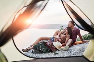 View from tent of couple lying a view of lake during hiking trip. avel Lifestyle concept adventure vacations outdoor photo