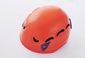 Isolated photo of climbing equipment - orange colored protective helmet