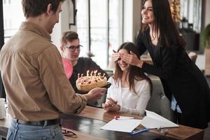 no abras los ojos uno de los empleados tiene cumpleaños hoy. compañeros de trabajo amistosos decide hacer una sorpresa para ella foto