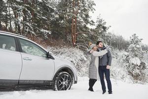 Showing beautiful landscape far away. Lovely couple have weekend at countryside at winter time photo