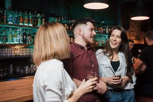 Man talks to a girls. Beautiful youth have party together with alcohol in the nightclub photo