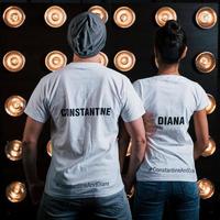 Back view of couple in shirts with their names on it standing next to studio lights photo