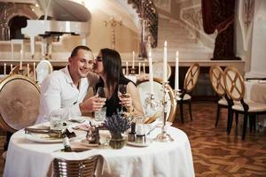pareja tan linda. una pareja hermosa tiene una cena romántica en un restaurante de lujo por la noche foto