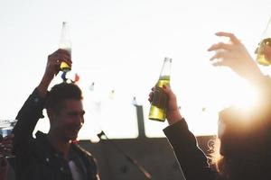 Hands in the air. It's rooftop party. Group of friends have holidays at sunny autumn day photo