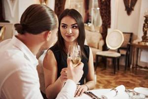 maquillaje perfecto. una pareja hermosa tiene una cena romántica en un restaurante de lujo por la noche foto