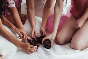 vista de cerca deliciosas galletas de chocolate en la fiesta de niñas. cuatro mujeres en ropa de noche foto