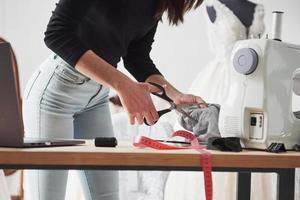 Close up view. Female fashion designer works on the new clothes in the workshop photo